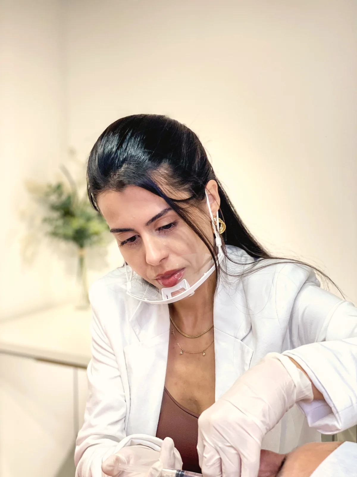 Dra. Flávia Mucci de jaleco branco durante um atendimento na Vip Estética