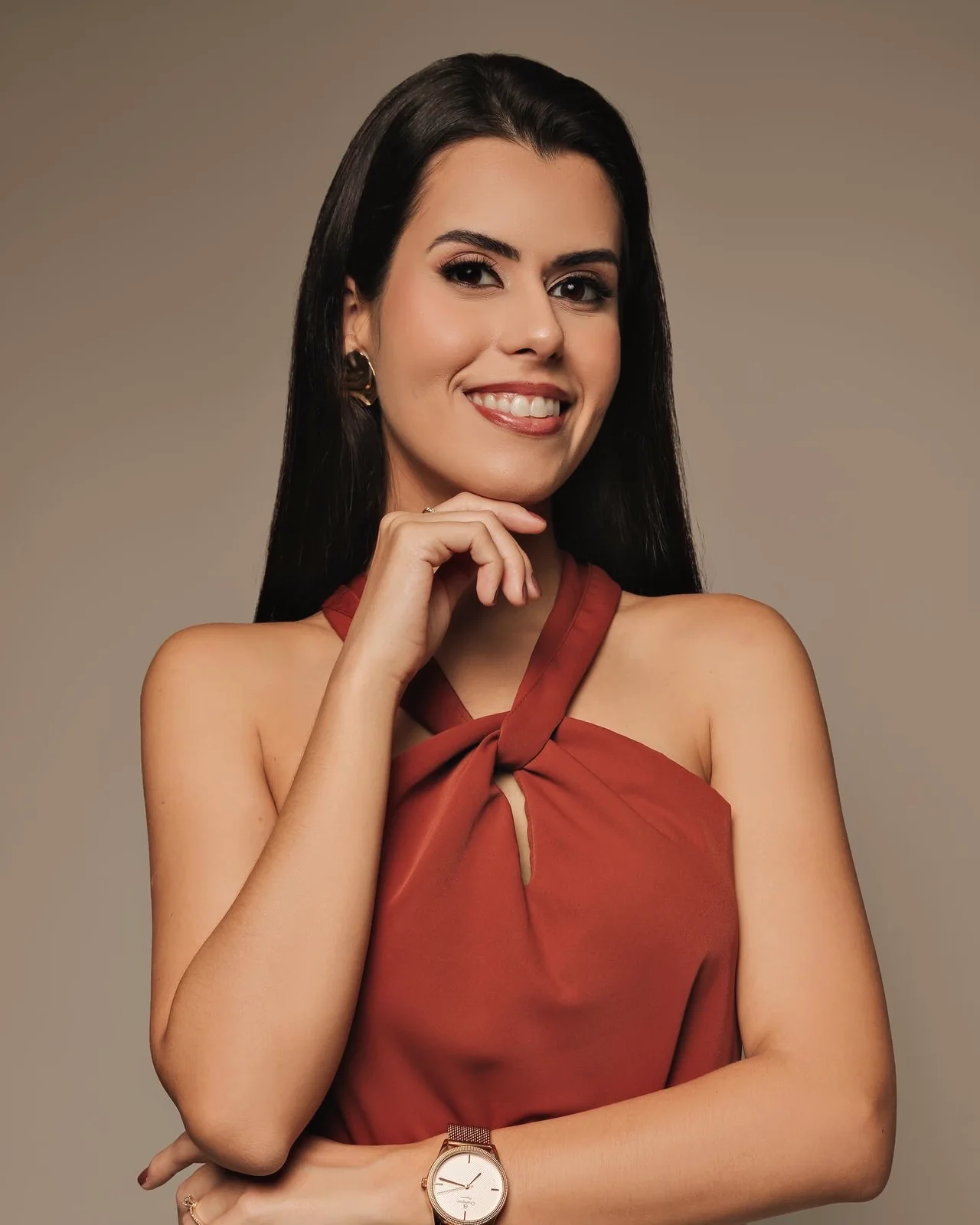 Dra. Flávia Mucci olhando para a câmera, com o queixo apoiado na mão