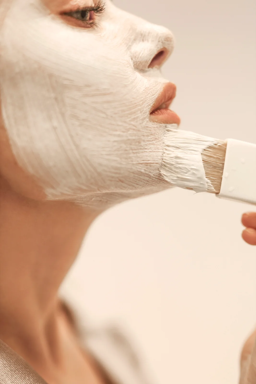 Pincel aplicando o peeling cremoso sobre a pele do rosto